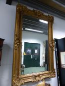 A RECTANGULAR MIRROR IN A GILT FRAME WITH ROCAILLE SHELL CORNERS AND CENTRES TO A DIAMOND DIAPER