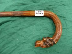 A VINTAGE WALKING STICK , THE HANDLE CARVED WITH DOGS HEAD AND WITH GLASS EYES . 93 CM LONG