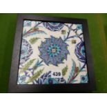 AN OTTOMAN STYLE KUTAHYA TILE, A TURQUOISE BORDERED BLUE FLOWER CENTRAL TO BUDS AND LEAVES, THE