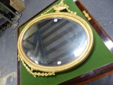 AN OVAL BEVELLED GLASS MIRROR IN GILT FRAME SURMOUNTED BY A SWAGGED BASKET OF FRUIT AND WITH TWO