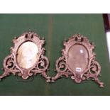 A PAIR OF GILT BRONZE EASEL BACKED FRAMES, THE OVAL OPENINGS ENCLOSED BY SCROLLS, FOLIAGE AND MASKS.