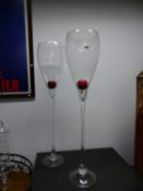 TWO OUTSIZE WINE GLASSES, THE CLEAR TULIP BOWLS ON STEMS AND CIRCULAR FEET. H 122cms.