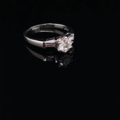 A PLATINUM AND DIAMOND TRILOGY RING. THE CENTRAL DIAMOND APPROX. ESTIMATED WEIGHT 0.70cts, I/SI2/3