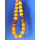 A CONTINUOUS STRING OF 21 ETHIOPIAN AMBER BEADS, PROBABLY FIRST HALF OF THE 20th C. VARYING IN SHAPE