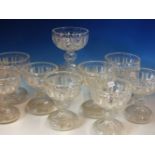 A SET OF NINE CUP SHAPED CLEAR GLASS VASES, THE SHALLOW BOWLS STRAWBERRY CUT WITH VERTICAL PANELS