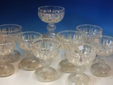 A SET OF NINE CUP SHAPED CLEAR GLASS VASES, THE SHALLOW BOWLS STRAWBERRY CUT WITH VERTICAL PANELS