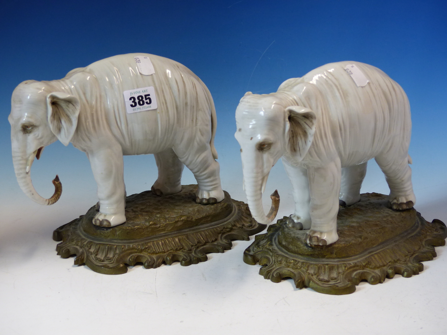 A PAIR OF ANTIQUE GERMAN PORCELAIN ELEPHANTS STANDING ON LATER ORMOLU BASES. W 26cms.