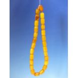 A CONTINUOUS STRING OF 26 UNIFORM ETHIOPIAN AMBER BEADS PROBABLY FIRST HALF OF THE 20th C. MEASURING