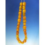 A STRING OF 27 ETHIOPIAN AMBER BEADS, PROBABLY FIRST HALF OF THE 20th.C. VARYING IN SHAPE AND