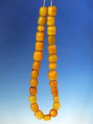A STRING OF 27 ETHIOPIAN AMBER BEADS, PROBABLY FIRST HALF OF THE 20th.C. VARYING IN SHAPE AND