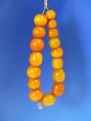 A CONTINUOUS STRING OF 16 UNIFORM ETHIOPIAN AMBER BEADS PROBABLY FIRST HALF OF THE 20th C. MEASURING