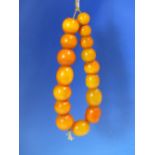 A CONTINUOUS STRING OF 16 UNIFORM ETHIOPIAN AMBER BEADS PROBABLY FIRST HALF OF THE 20th C. MEASURING