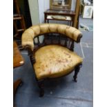 A VICTORIAN CARVED MAHOGANY TUB FORM DESK ARMCHAIR COVERED IN BUTTONED TAN LEATHER.