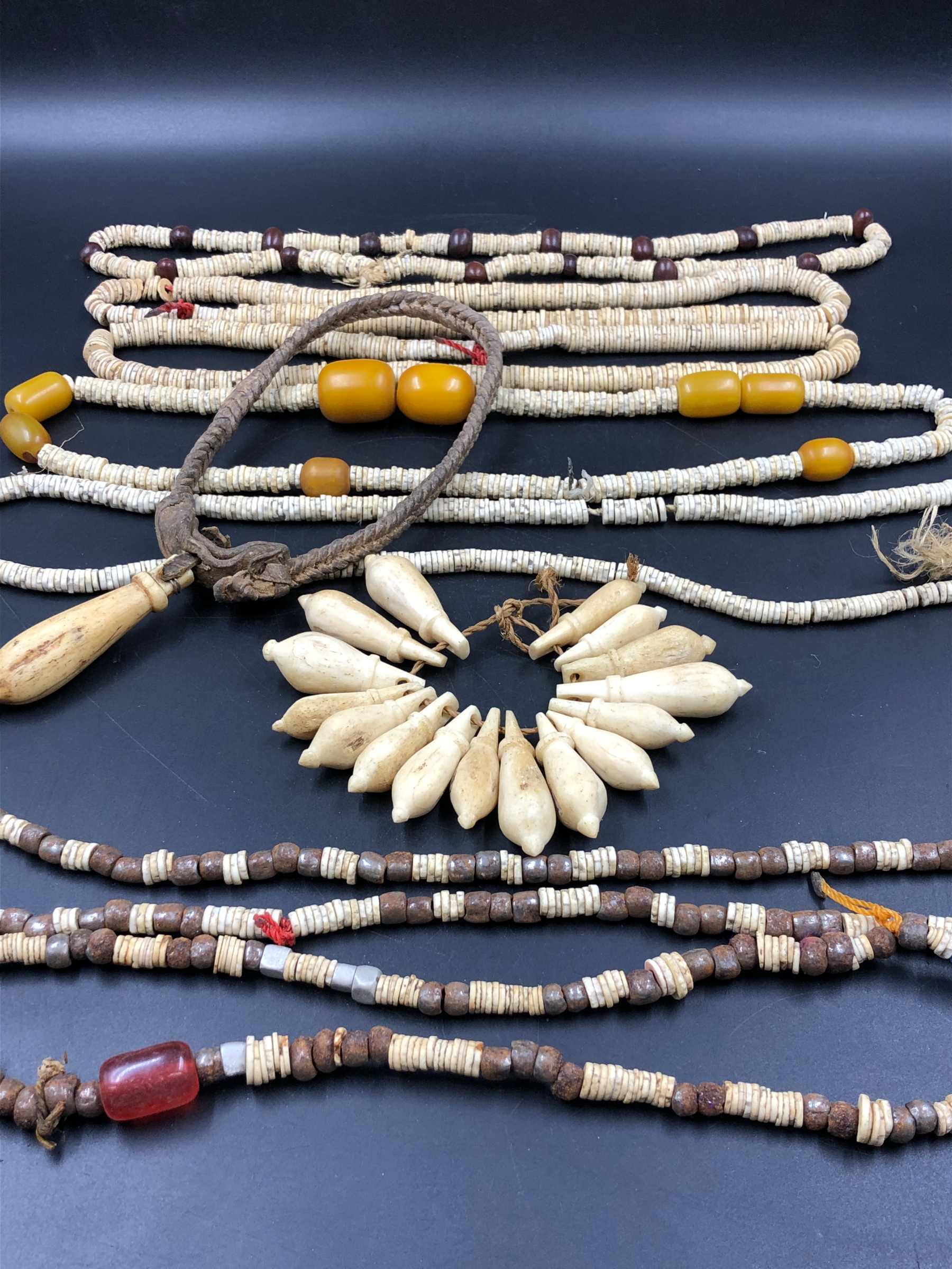 NINE STRANDS OF ETHNIC BEADED NECKLETS TO INCLUDE AMBER, BONE, IRON ETC.