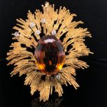 ANDREW GRIMA. AN 18ct GOLD, CITRINE AND DIAMOND BROOCH. THE OVAL CUT CITRINE SURMOUNTED BY BURSTS OF