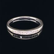 A 9ct WHITE GOLD HALF ETERNITY CHANNEL SET DIAMOND RING. TEN BRILLIANT CUT DIAMONDS IN A PLAIN