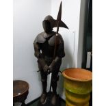 A REPRODUCTION SUIT OF MEDIAEVAL ARMOUR WORN BY A LIFE SIZE MANNEQUIN STANDING HOLDING A HALBERD