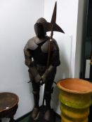 A REPRODUCTION SUIT OF MEDIAEVAL ARMOUR WORN BY A LIFE SIZE MANNEQUIN STANDING HOLDING A HALBERD