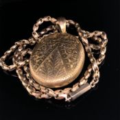 AN ANTIQUE 15ct GOLD OVAL ORNATE SCROLL LOCKET SUSPENDED ON A 9ct GOLD ANTIQUE DOVETAIL STYLE