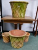 A GROUP OF EIGHT LATTICE DECORATED TERRACOTTA GARDEN PLANTERS OF VARYING SIZES. LARGEST PAIR H. 46 x