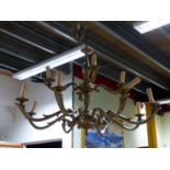 A BRASS TWELVE LIGHT TWO TIER CHANDELIER ON A COLUMN WITH GADROONING, TO THE CEILING FITTING. H