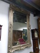 A RECTANGULAR MIRROR IN A SILVERED FRAME WITH ROCAILLE SHELL CORNERS AND CENTRES ON A DIAMOND DIAPER