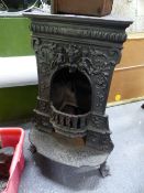 A VICTORIAN CAST IRON STOVE, THE FRONT WITH RELIEF CHILDREN, FOLIAGE AND FLOWERS ALL BEFORE THE HALF