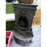 A VICTORIAN CAST IRON STOVE, THE FRONT WITH RELIEF CHILDREN, FOLIAGE AND FLOWERS ALL BEFORE THE HALF