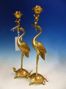 A PAIR OF CHINESE GILT METAL CANDLESTICKS, THE LOTUS NOZZLES SUPPORTED IN THE BEAKS OF CRANES