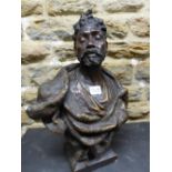 A PAINTED TERRACOTTA BUST OF A BEARDED NUBIAN HIS HAIR DRESSED INTO A TOP KNOT. H 44cms.