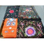 THREE CHINESE FLORAL EMBROIDERED BLACK SILK SHAWLS TOGETHER WITH A TERRACOTTA RED SHAWL