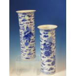 A PAIR OF CHINESE BLUE AND WHITE SLEEVE VASES PAINTED WITH BUDDHIST LIONS AMONGST CLOUDS BELOW THE
