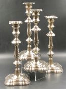 A SET OF FOUR HALLMARKED SILVER WEIGHTED BASE CANDLESTICKS, COMPLETE WITH REMOVABLE DRIP PANS, DATED