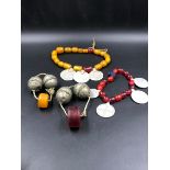 TWO STRANDS OF AMBER AND METAL DISC PEDANTS, TOGETHER WITH TWO FURTHER METAL LARGE BEADS AND AN