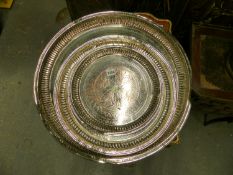 A GRADUATED SET OF THREE SILVER ON COPPER TRAYS, EACH WITH A QUATREFOIL CENTRAL TO FLUTED CAVETTO