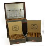 Vintage cigar humidor, mahogany with brass trim, with two boxes of old cigars.