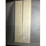 Pair of custom painted wood doors having raised panels, 108" H x 20" W x 1 3/4" D. Provenance: