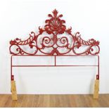 Cast iron Venetian design headboard, painted red, 55" H x 54" W. Provenance: From a Delray Beach,