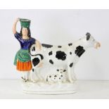 Staffordshire figure with maid and cow, 9 1/2" H. Provenance: From a Saugus, Massachusetts estate.