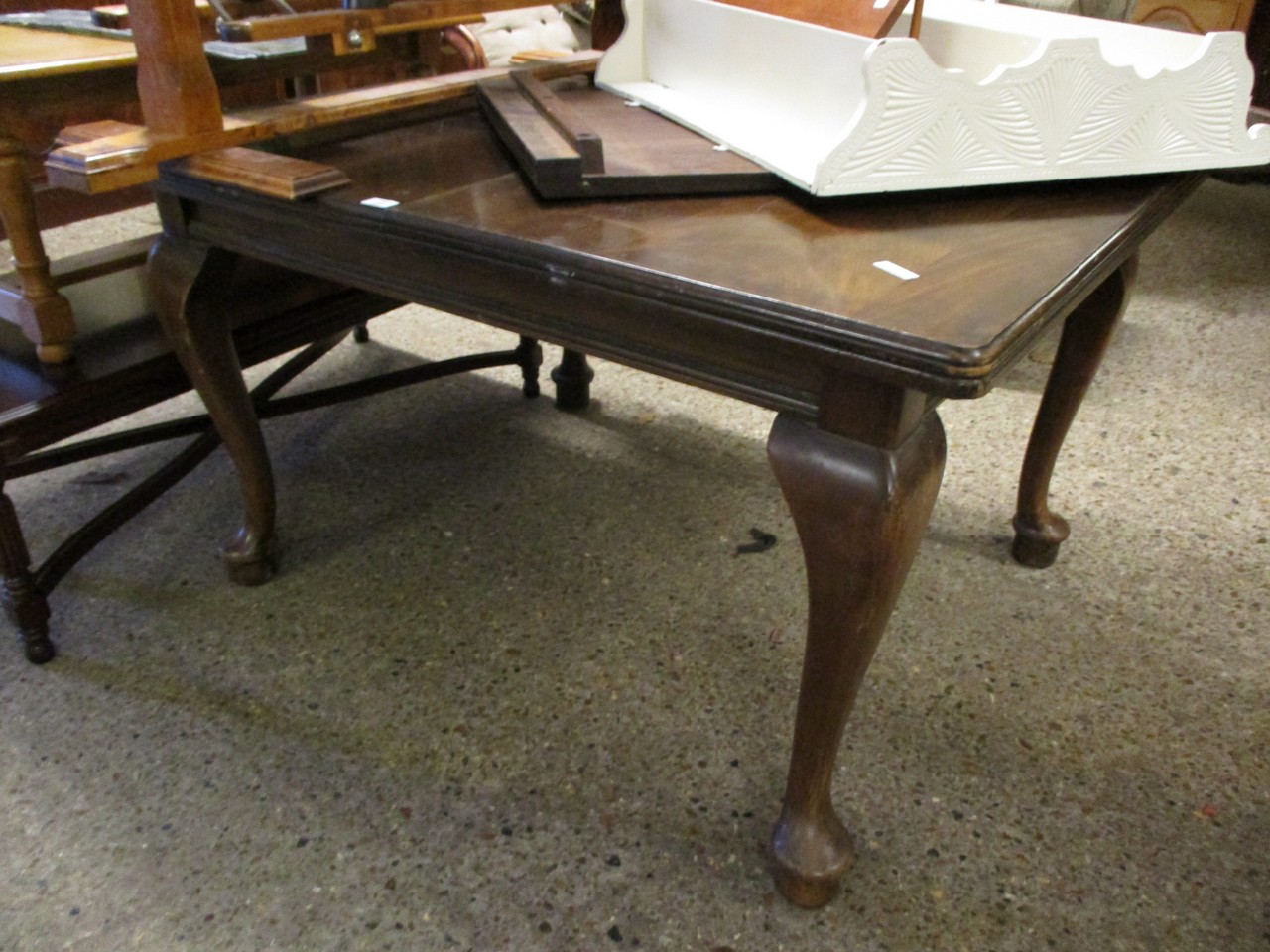 MAHOGANY FRAMED EXTENDING DINING TABLE WITH ONE EXTRA LEAF RAISED ON PAD FEET