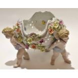 Large jardiniere with a floral encrusted bowl supported by three cherubs^ possibly by Samson