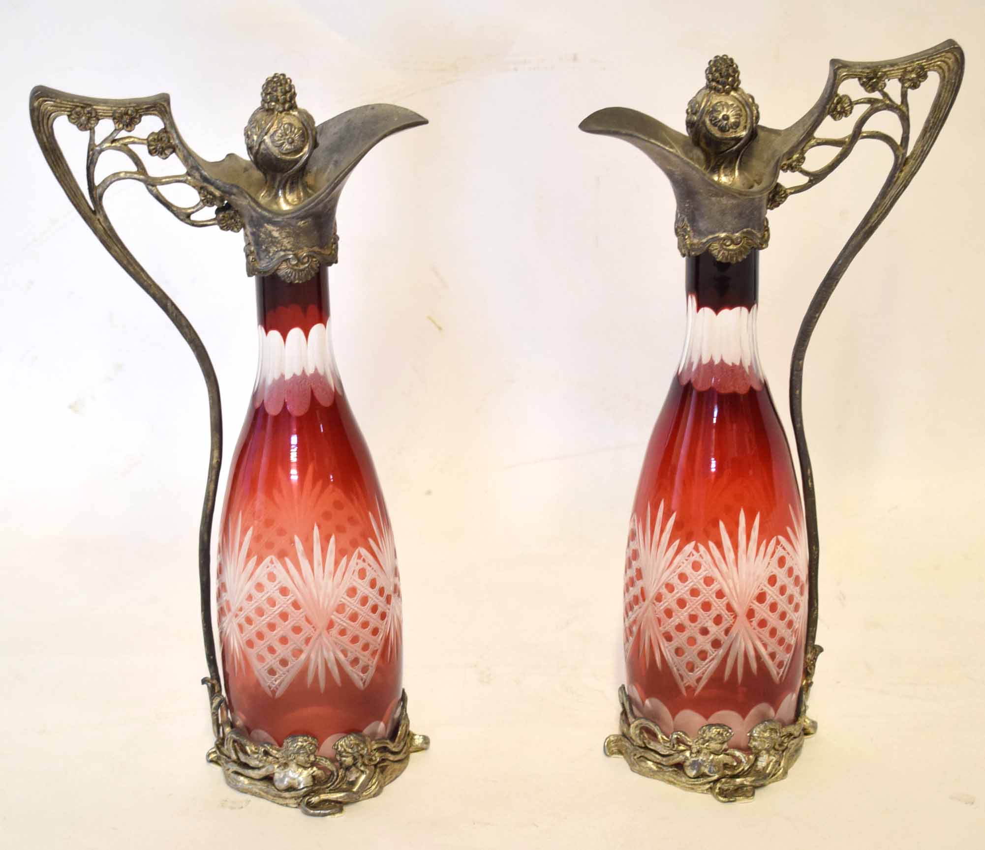 Pair of WMF style plated claret jugs with Bohemian glass bodies^ the handles and bases moulded