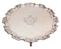 George V plain small silver waiter of circular form with |Chippendale| edge and supported on four