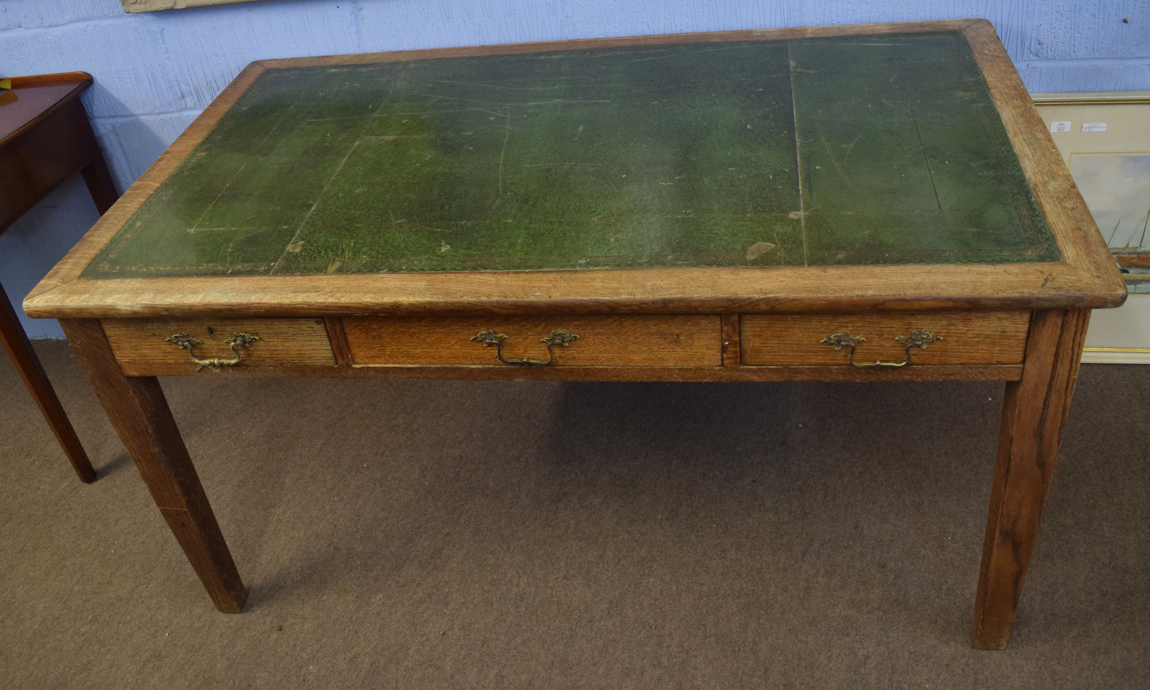 Late 19th century light oak desk^ gilt tooled green leather inset (a/f) and three frieze drawers