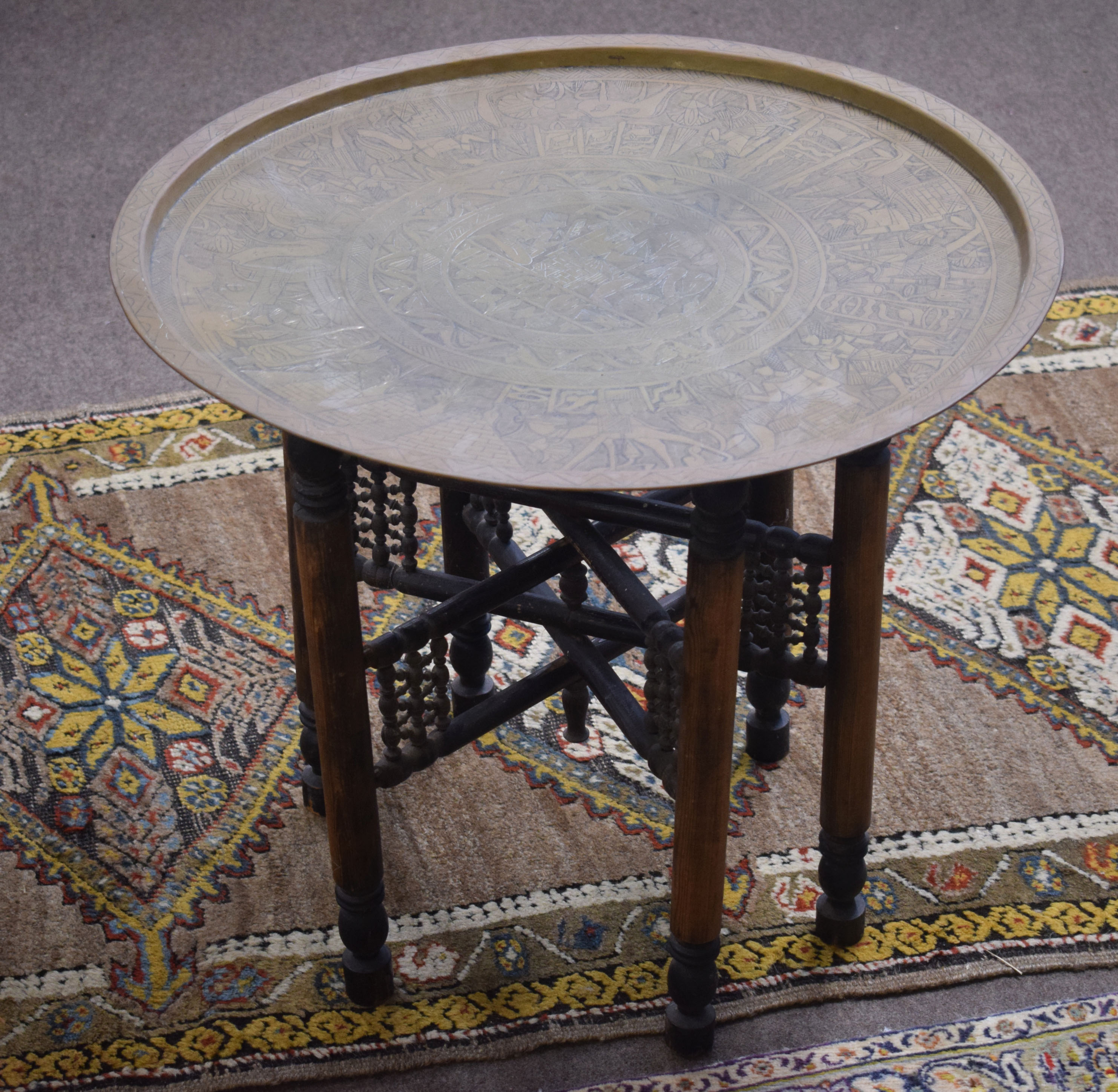 Early 20th century Benares table with brass top and folding support^ 63cm diam