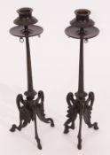 Pair of patinated bronze candlesticks^ each with circular sconces^ embossed with berries and foliage