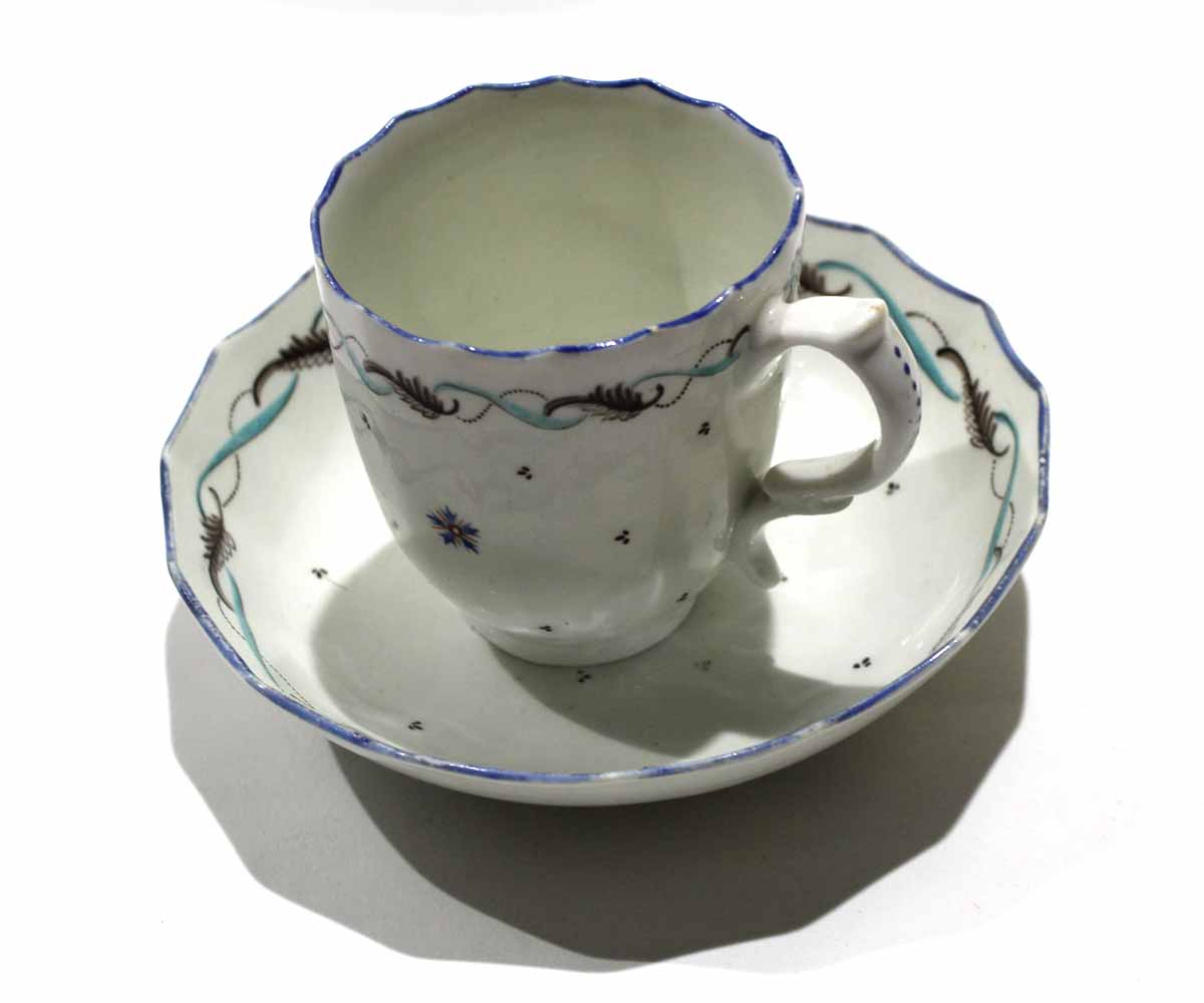 Lowestoft cup and saucer^ circa 1790^ decorated with a polychrome feather type design with a