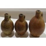 Group of three stoneware flagons^ 18th/19th century^ one with an orange peel type glaze (3)