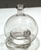 Globular glass vase raised on three stub feet^ 20cm high