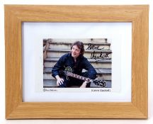 Photo of Steve Hackett in light oak frame, the photo signed by Hackett Note: sold on behalf of a